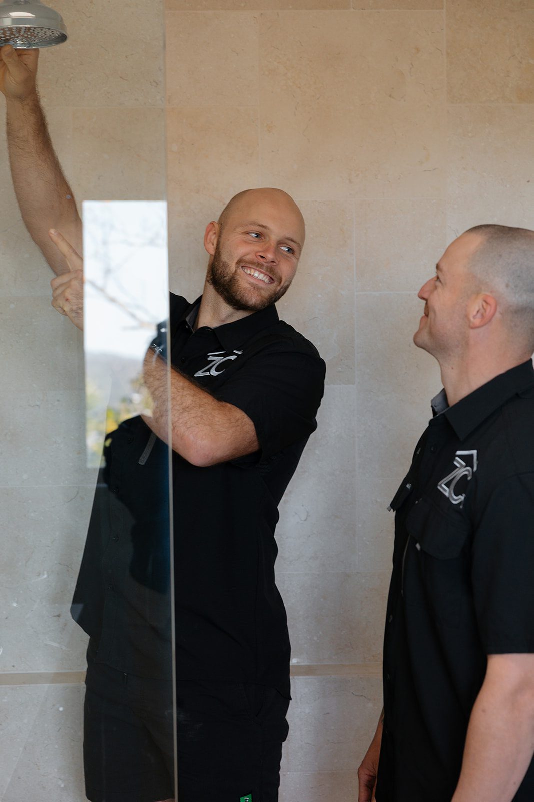 Two ZC plumbers fitting a shower head in a renovated Central Coast bathroom