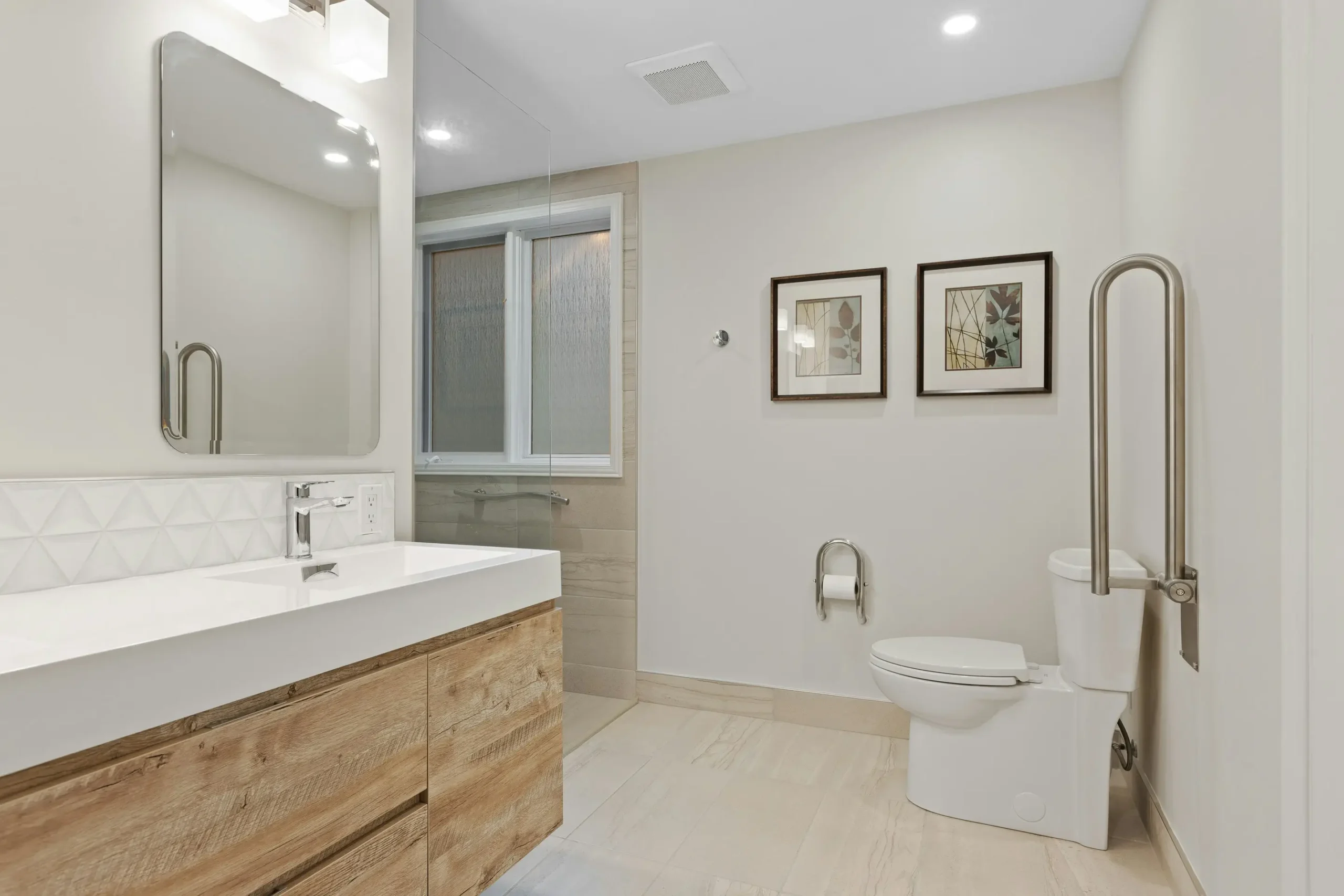 Accessible bathroom renovation with grab rails beside the toilet and a timber vanity