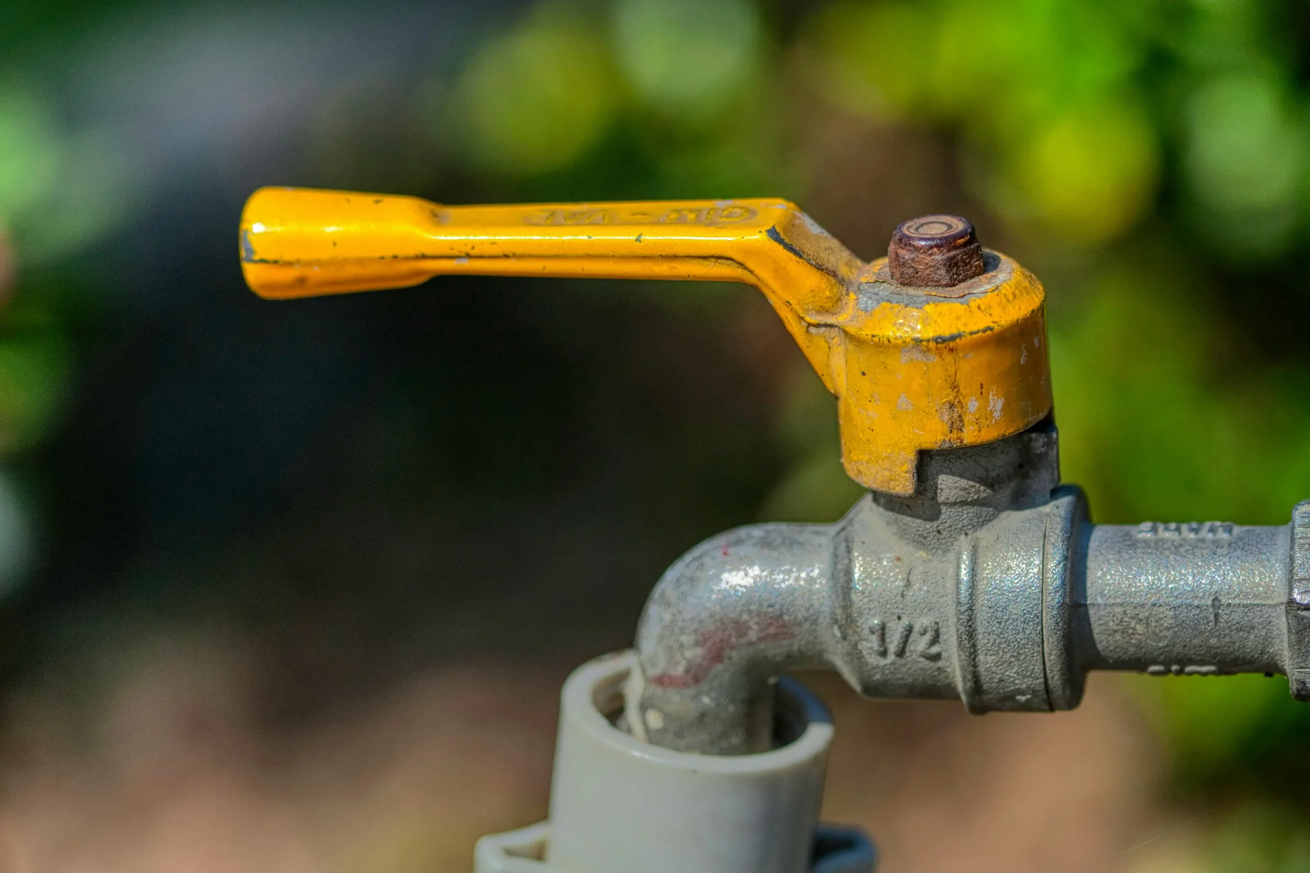 Close-up of a yellow-handled gas ball valve on a pipe